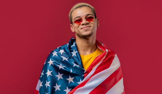 A young person of color draped in an American flag